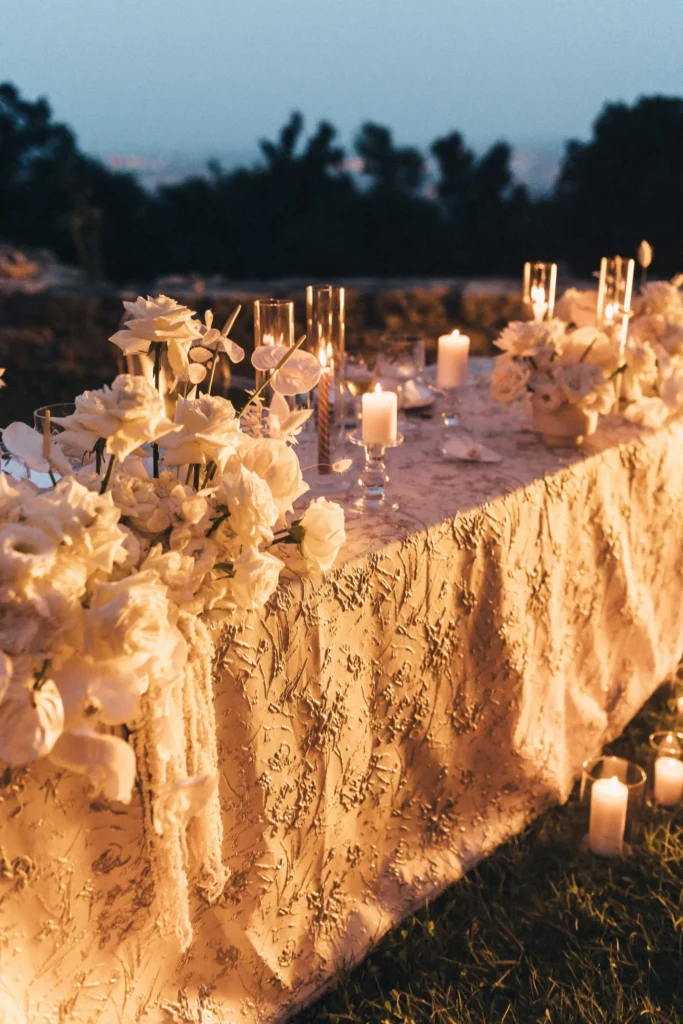 Elegant table setting adorned with candles and white flowers, capturing the romantic ambiance of an elopement at Medvedgrad Castle in Zagreb during dusk.