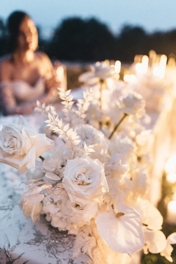 A bride near a beautifully decorated table with white roses and candles, capturing the romantic atmosphere of an elopement wedding at Medvedgrad Castle in Zagreb.