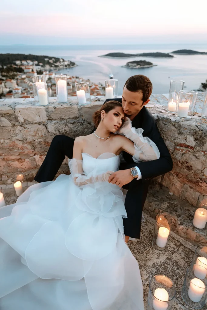 Couple during their elopement at the Spanish fortress in Hvar, surrounded by candles with a scenic view of the sea and islands.